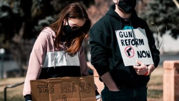 woman in black and white long sleeve shirt holding brown cardboard box