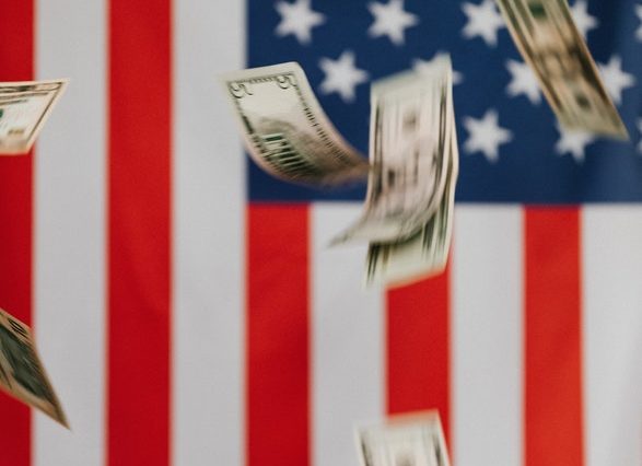 National flag of United States of America on background and dollars falling down