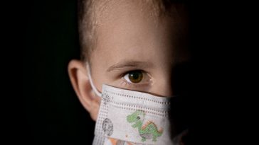 baby with white and green diaper