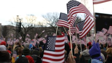 people holding us a flag during daytime