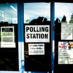 polling station poster on clear glass door