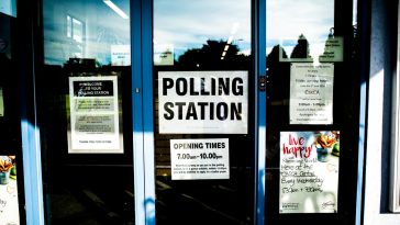 polling station poster on clear glass door